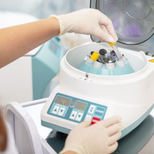 Medical centrifuge. Scientist loading a sample to centrifuge machine in the medical or scientific laboratory